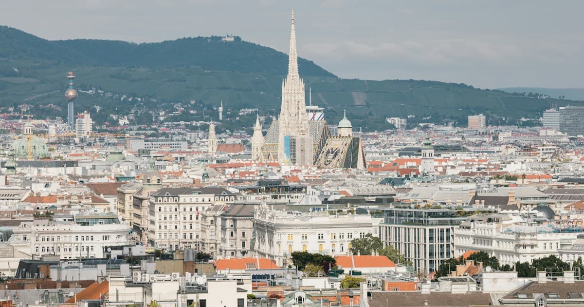 Blick über die Dächer der Wiener Innenstadt mit dem Stephansdom, im Hintergrund der Kahlenberg bei Tageslicht