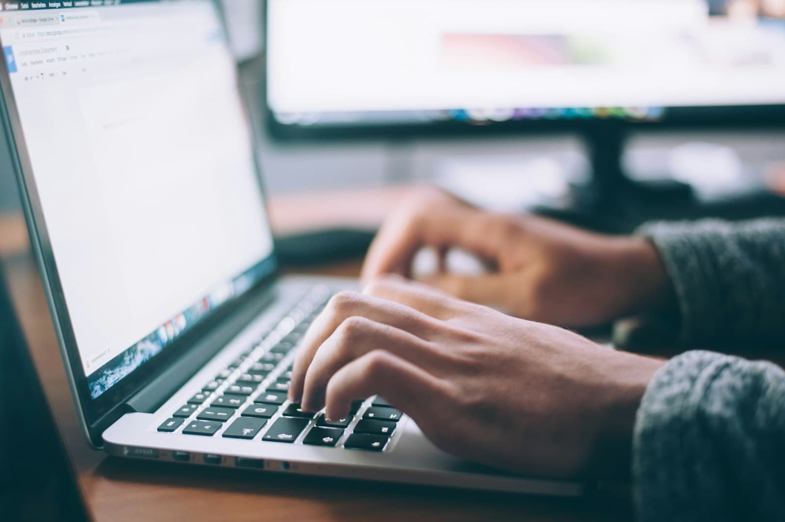 Freelancerin arbeitet entspannt im Café mit Laptop, im Hintergrund eine Wiener Altstadtkulisse als Sinnbild für ortsunabhängiges Arbeiten mit Wiener Geschäftsadresse